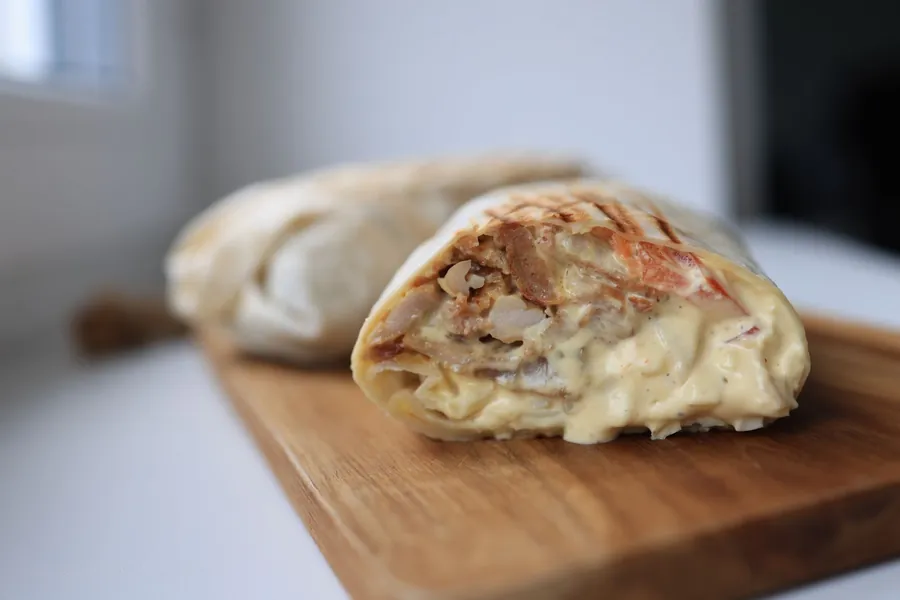 Chicken shawarma wrap cut open with creamy garlic sauce