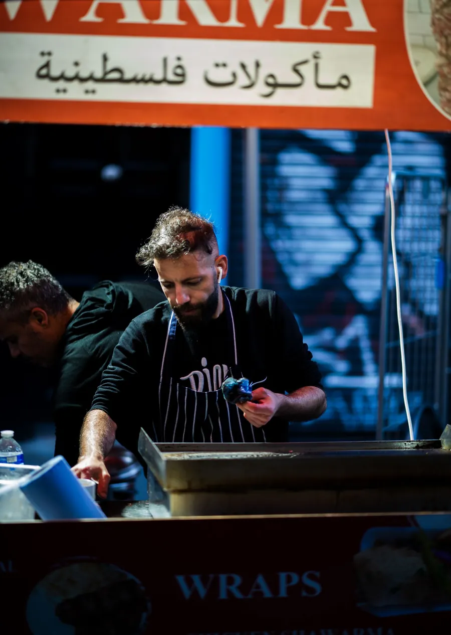 A cook preparing fresh shawarma in the Al Mouna kitchen
